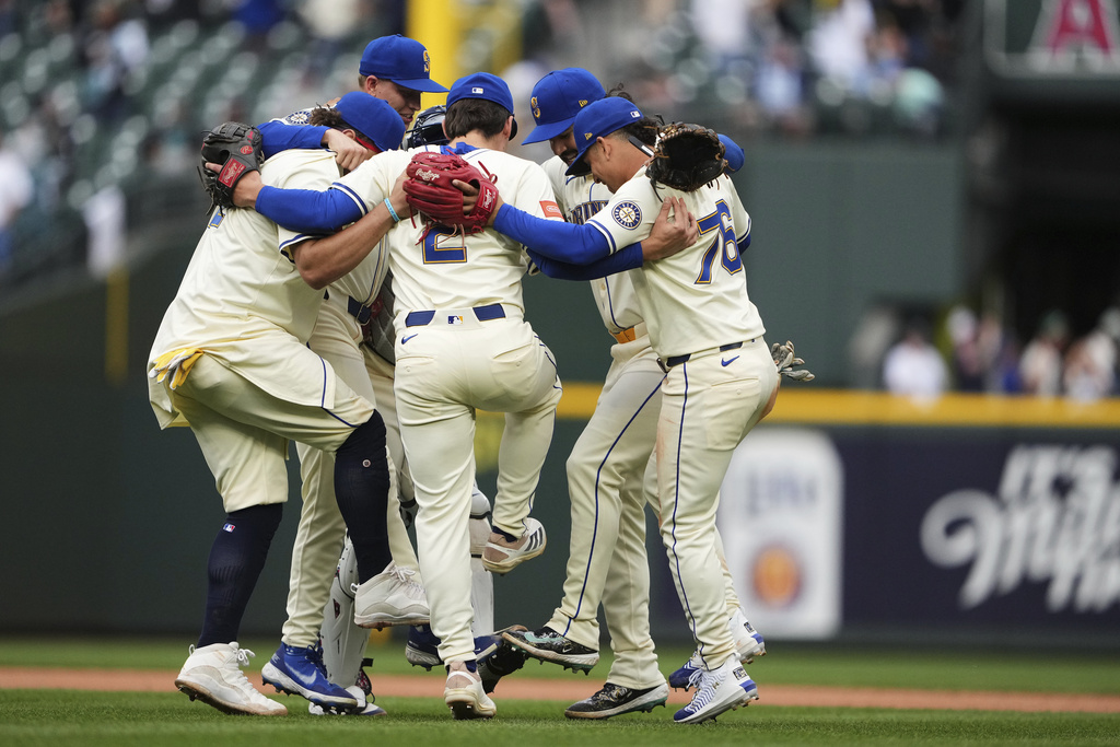 The Seattle Mariners infield, including shortstop Cole Young (2) and second baseman Leo Rivas (76) celebrate a win over the Los Angeles Angels in a baseball game Sunday, Sept. 14, 2025, in Seattle. (AP Photo/Lindsey Wasson)