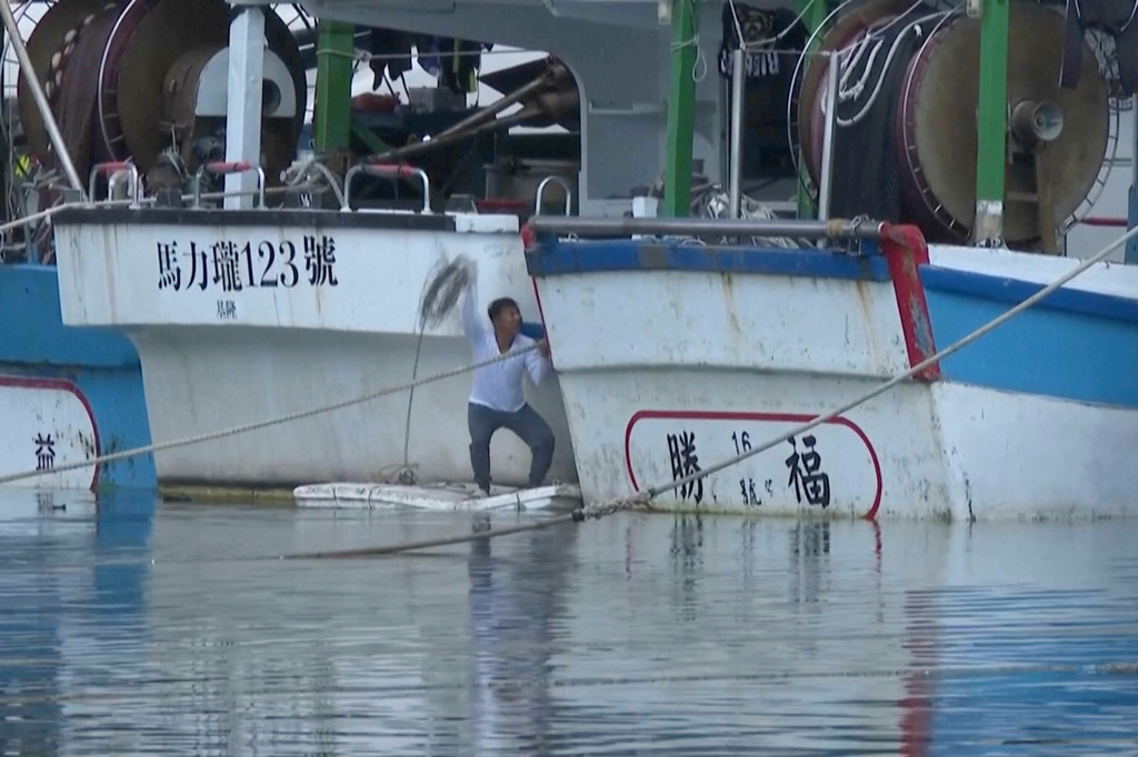 In this image made from video, a man secures a boat at Shen'ao Fishing Port, ahead of Typhoon Bavi along the coast of New Taipei City, Taiwan on Thursday, July 9, 2026. (AP Photo/Taijing Wu)