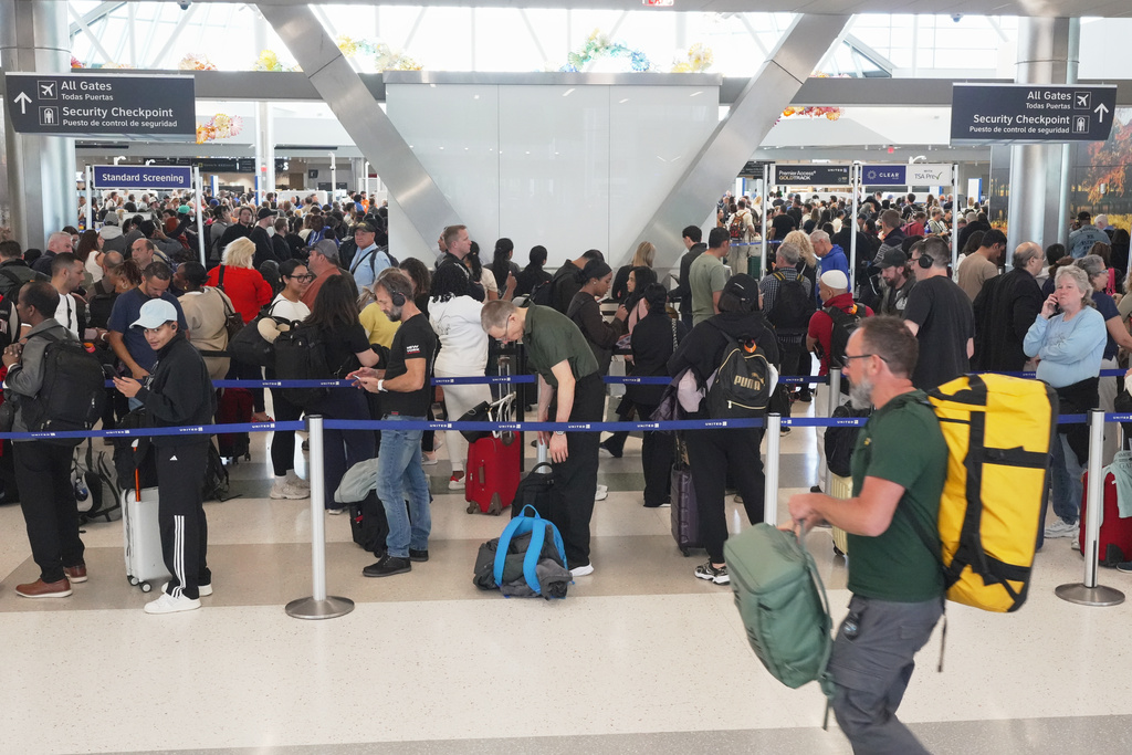 Airline passengers wait in long lines to get through the TSA security screening at George Bush Intercontinental Airport in Houston on Wednesday, March 18, 2026. (AP Photo/Lekan Oyekanmi)