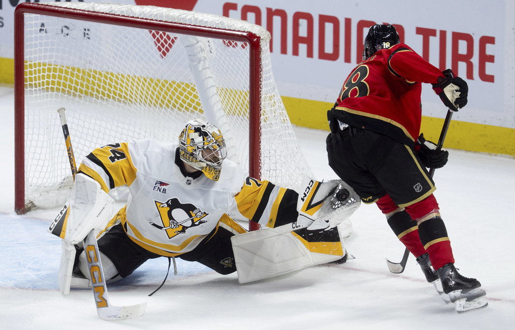 Pittsburgh Penguins goaltender Stuart Skinner (74) makes a glove save on Ottawa Senators Tim Stutzle (18) during overtime in an NHL hockey game in Ottawa, Ontario, Thursday, March 26, 2026. (Adrian Wyld/The Canadian Press via AP)