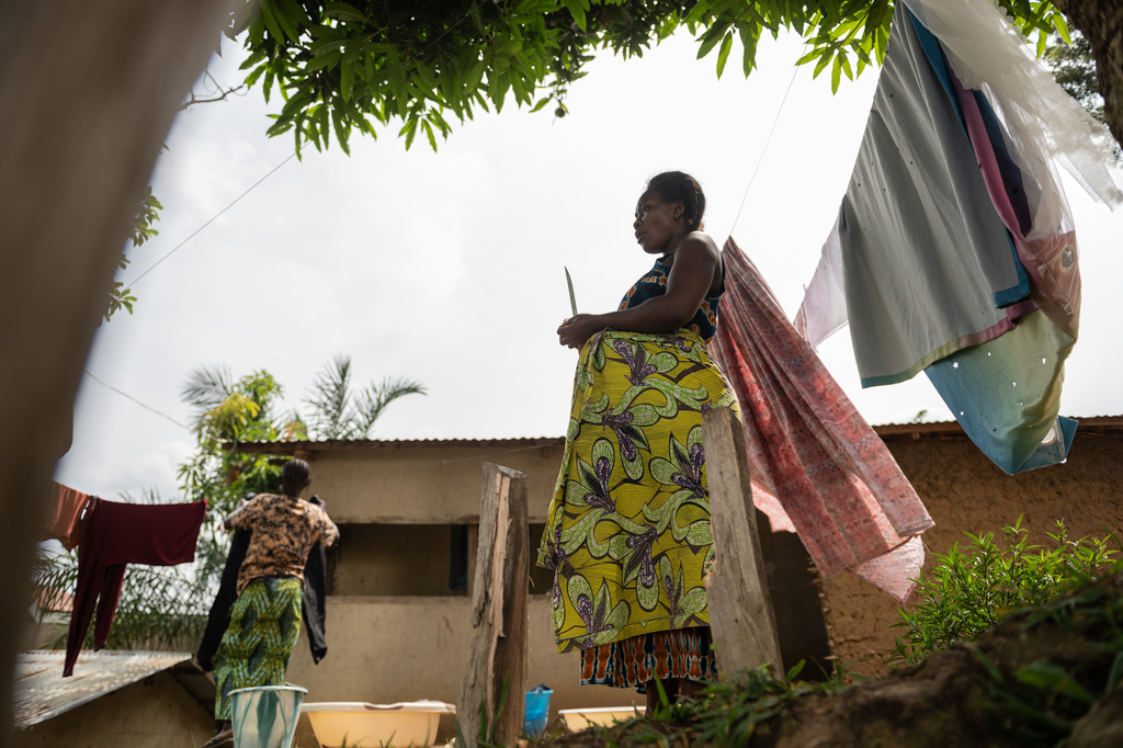 Elodie, right, a mother of one who is eight months pregnant, stands outside her house in Bunia, northeastern, Congo, Tuesday, June 16, 2026. (AP Photo/Moses Sawasawa)
