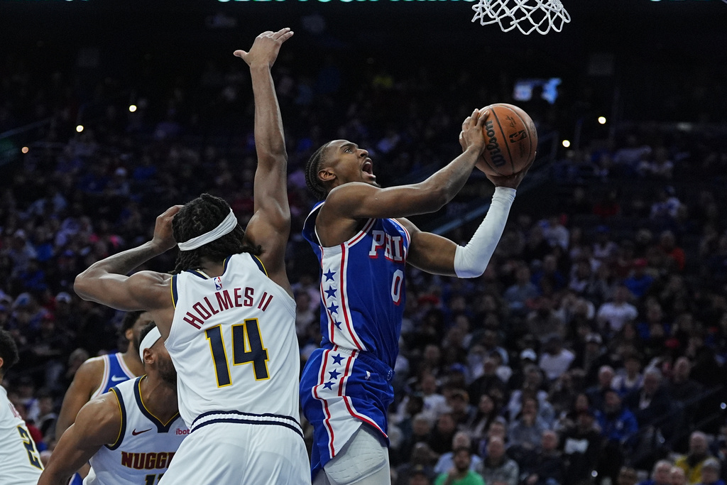 Philadelphia 76ers' Tyrese Maxey (0) goes up to shoot against Denver Nuggets' Daron Holmes II during the first half of an NBA basketball game Monday, Jan. 5, 2026, in Philadelphia. (AP Photo/Matt Rourke)