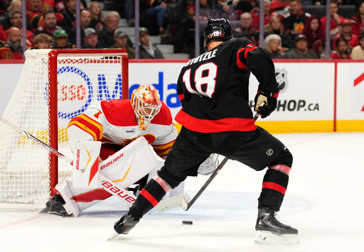 Calgary Flames goaltender Devin Cooley (1) looks to make a save against Ottawa Senators' Tim Stutzle (18) during second period NHL hockey action in Ottawa, on Thursday, Oct. 30, 2025. (Justin Tang/The Canadian Press via AP) Calgary Flames goaltender Devin Cooley (1) looks to make a save against Ottawa Senators' Tim Stutzle (18) during second period NHL hockey action in Ottawa, on Thursday, Oct. 30, 2025. (Justin Tang/The Canadian Press via AP)