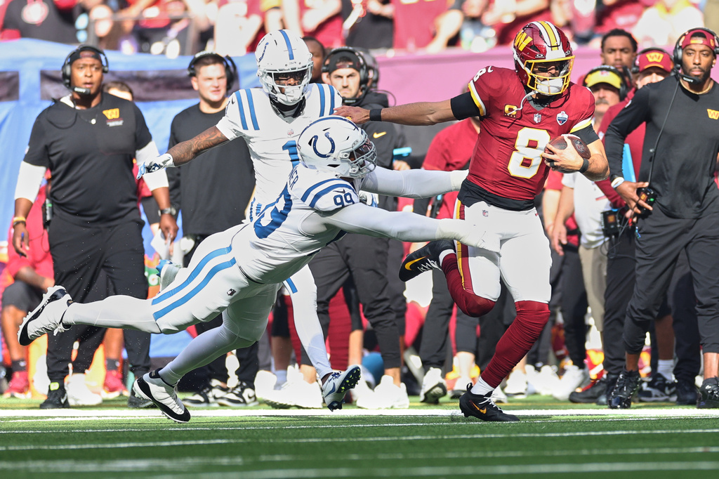 Washington Commanders quarterback Marcus Mariota (8) is tackled by Indianapolis Colts defensive tackle DeForest Buckner (99) during an NFL football game in London, Sunday, Oct. 4, 2026. (AP Photo/Ian Walton)