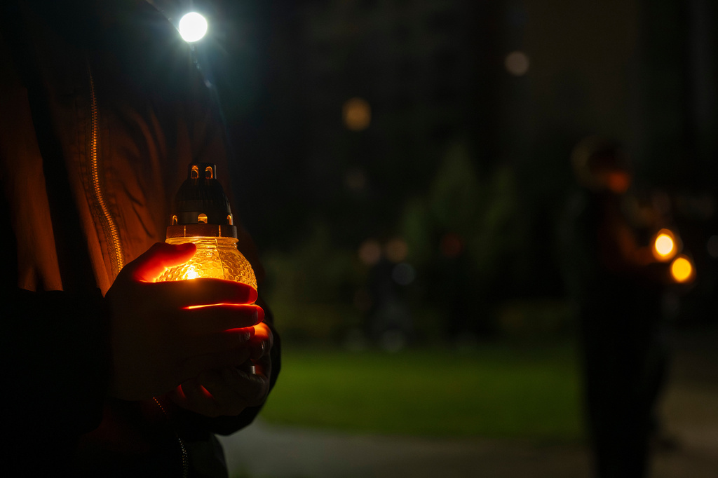 People bring candles at a memorial dedicated to firefighters and workers who died after the 1986 Chornobyl (Chernobyl) nuclear disaster, ahead of its 40th anniversary in Slavutych, Ukraine, Saturday, April 25, 2026. Chornobyl is the Ukrainian name for the city. (AP Photo/Dan Bashakov)
