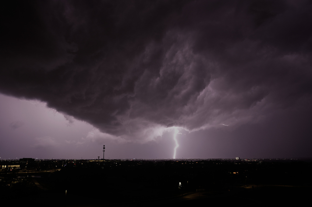 Lightning flashes as a thunderstorm passes in the distance Monday, April 13, 2026, in Lenexa, Kan. (AP Photo/Charlie Riedel)