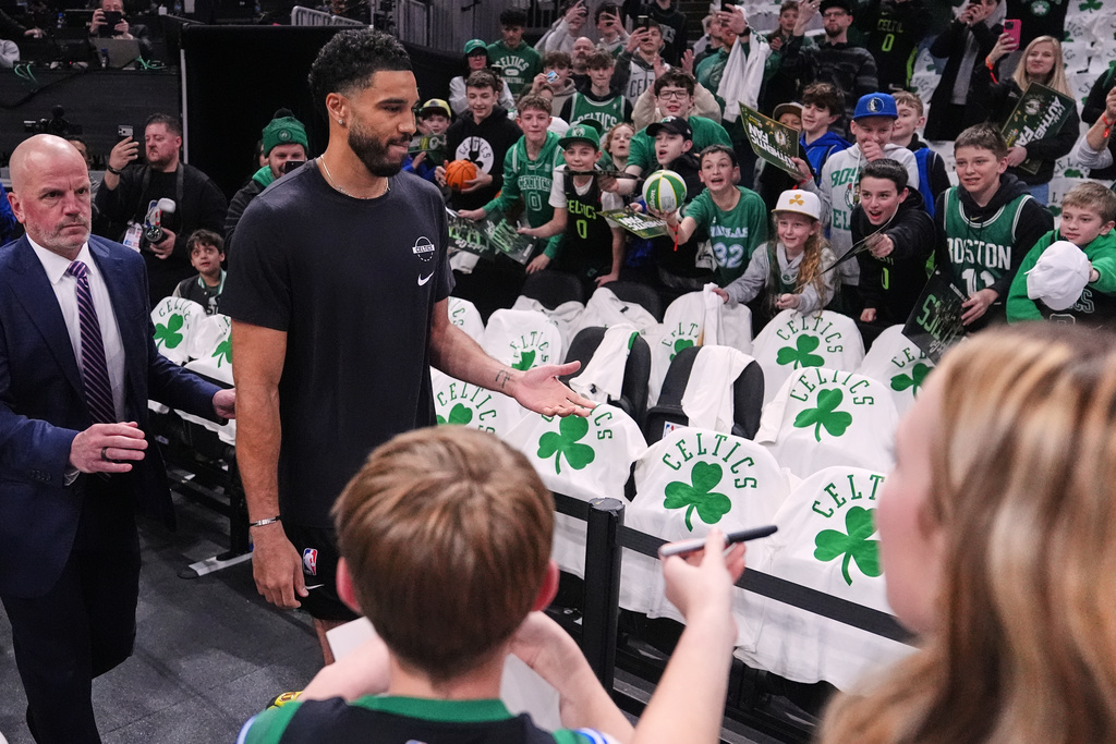 Boston Celtics forward Jayson Tatum, second from left, who has not played since injuring his achilles tendon during the 2025 NBA playoffs, is greeted by fans during a practice prior to an NBA basketball game against the Dallas Mavericks, Friday, March 6, 2026, in Boston. (AP Photo/Charles Krupa)