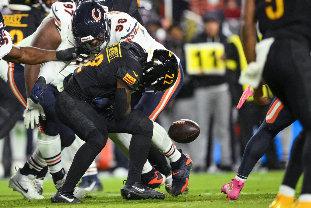 Washington Commanders running back Jacory Croskey-Merritt (22)fumbles the ball as he is hit by Chicago Bears defensive end Montez Sweat (98) during the first half of an NFL football game Monday, Oct. 13, 2025, in Landover, Md. (AP Photo/Nick Wass)