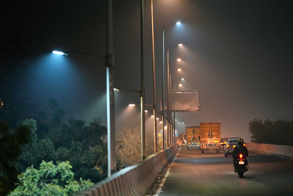Traffic moves on a smog-filled night in New Delhi, India, Tuesday, Nov. 18, 2025. (AP Photo/Manish Swarup)
