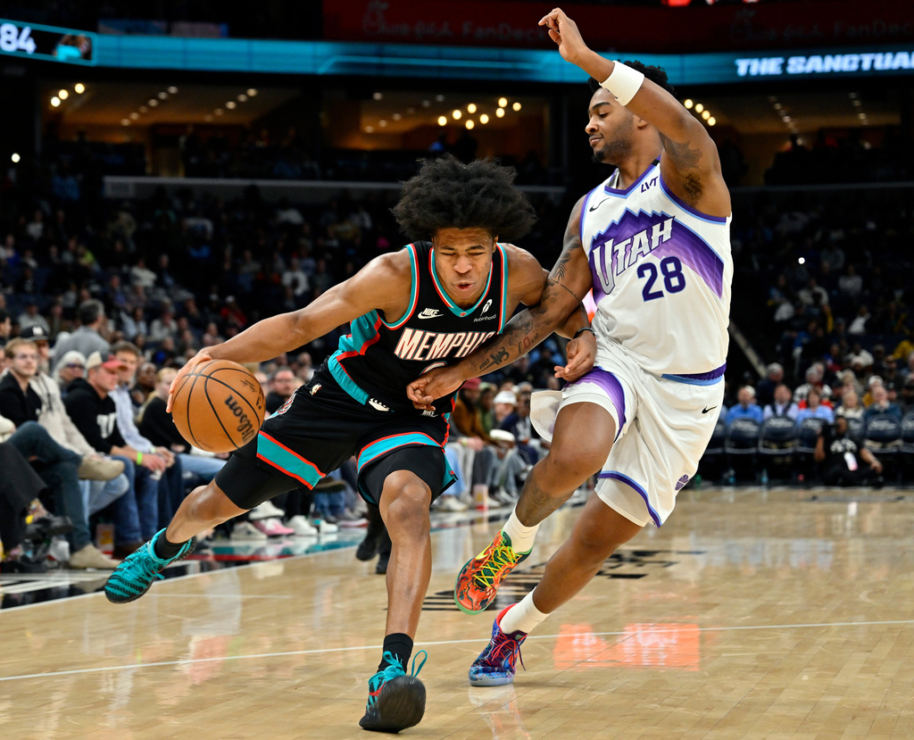 Memphis Grizzlies forward Jaylen Wells, left, drives against Utah Jazz forward Brice Sensabaugh (28) in the second half of an NBA basketball game Friday, Dec. 12, 2025, in Memphis, Tenn. (AP Photo/Brandon Dill)