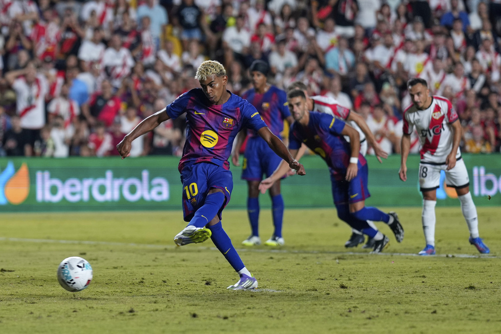 Barcelona's Lamine Yamal scores the opening goal from the penalty spot during the Spanish La Liga soccer match between Rayo Vallecano and FC Barcelona at the Vallecas stadium in Madrid, Spain, Sunday, Aug. 31, 2025. (AP Photo/Manu Fernandez)
