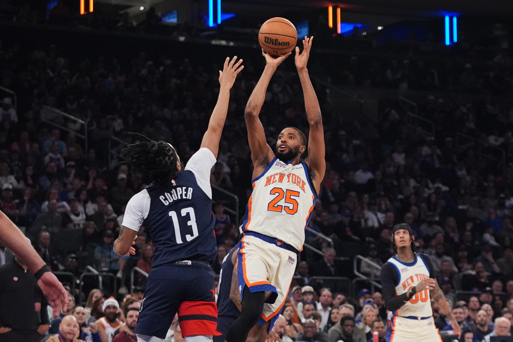 New York Knicks' Mikal Bridges (25) shoots over Washington Wizards' Sharife Cooper (13) during the first half of an NBA basketball game Sunday, March 22, 2026, in New York. (AP Photo/Frank Franklin II)