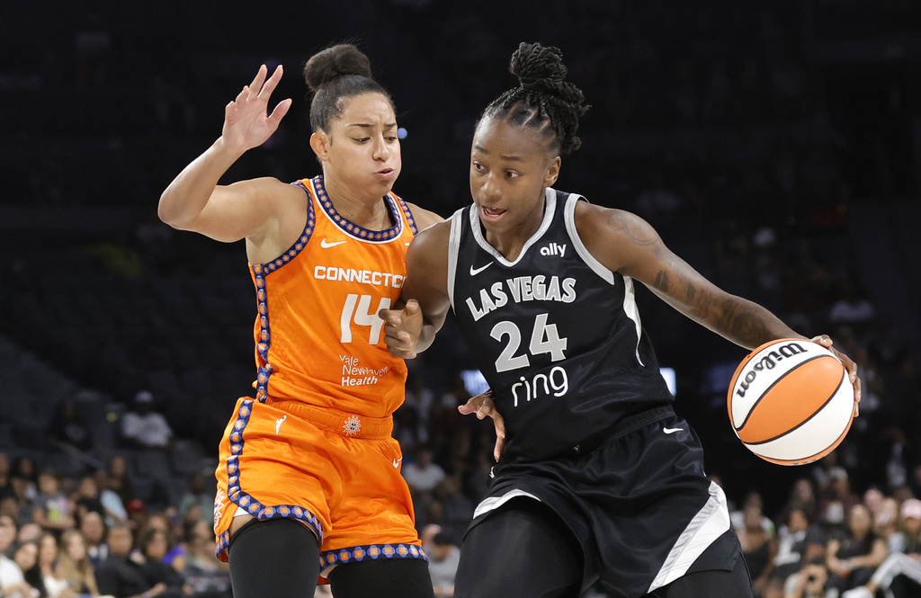 Las Vegas Aces guard Jewell Loyd (24) drives against Connecticut Sun guard Bria Hartley (14) during the first half of a WNBA basketball game Sunday, Aug. 10, 2025, in Las Vegas. (Steve Marcus/Las Vegas Sun via AP)