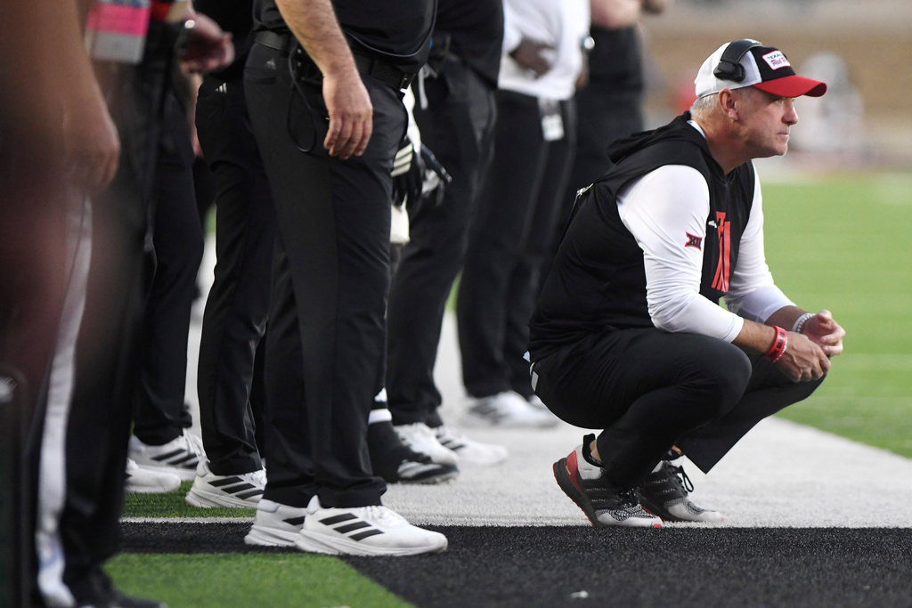 Texas Tech head coach Joey McGuire squats on the sidelines during the second quarter of an NCAA college football game against Kansas, Saturday, Oct. 11, 2025, in Lubbock, Texas. (AP Photo/Annie Rice)