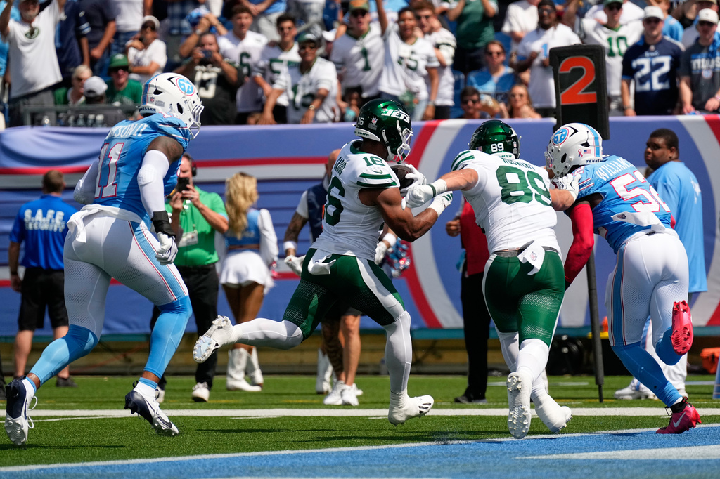 New York Jets tight end Kenyon Sadiq (16) runs in for a touchdown as tight end Jeremy Ruckert (89) tries to hold off Tennessee Titans linebacker James Williams Sr. (52), during the first half of an NFL football game, Sunday, Sept. 13, 2026, in Nashville, Tenn. (AP Photo/George Walker IV)