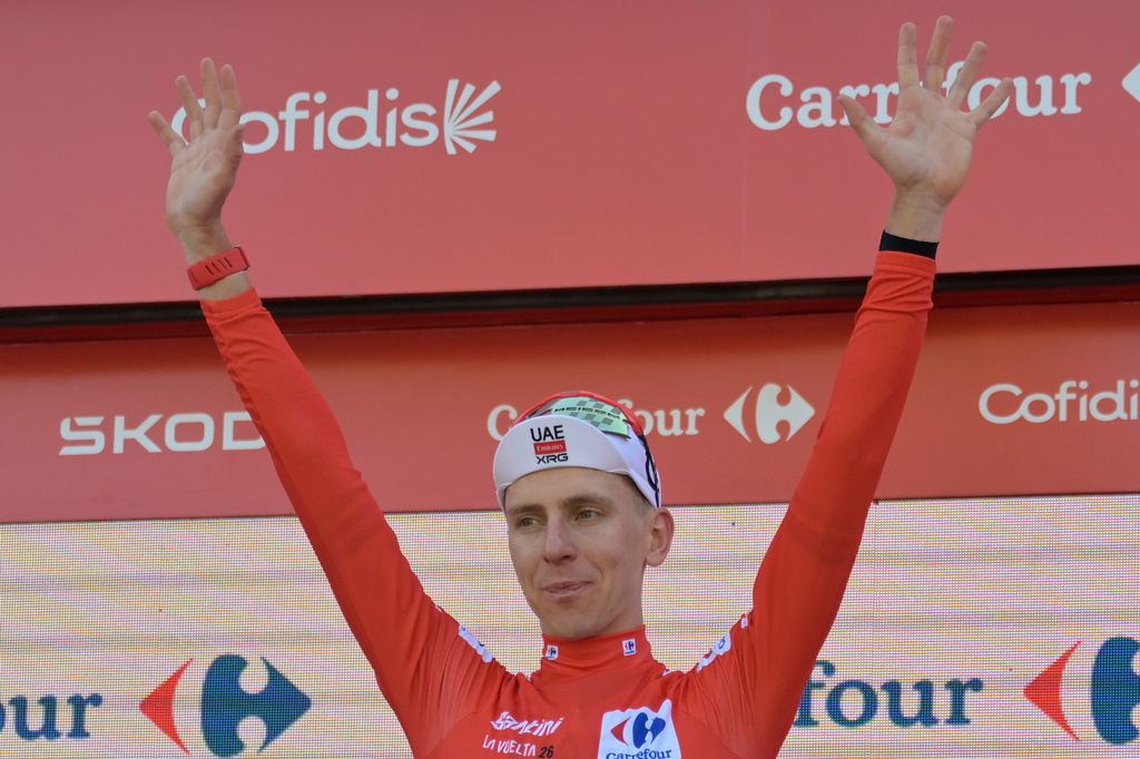 Slovenia's Tadej Pogacar, wearing the overall leader's red jersey celebrates on the podium after the second stage of the La Vuelta cycling race, with start in Monaco and finish in Manosque, France, Sunday, Aug. 23, 2026. (AP Photo/Philippe Magoni)