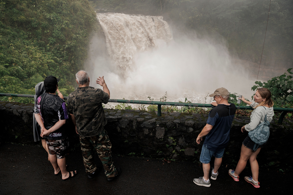 Visitors stand at Rainbow Falls after the passing of Hurricane Lala in Hilo, Hawaii, Sunday, Aug. 16, 2026. (Stephen Lam/San Francisco Chronicle via AP)