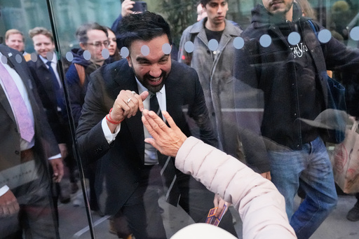 New York City mayoral candidate Zohran Mamdani waves to Rita Bellevue as she waits at a bus stop in New York, Monday, Oct. 27, 2025. (AP Photo/Seth Wenig) New York City mayoral candidate Zohran Mamdani waves to Rita Bellevue as she waits at a bus stop in New York, Monday, Oct. 27, 2025. (AP Photo/Seth Wenig)