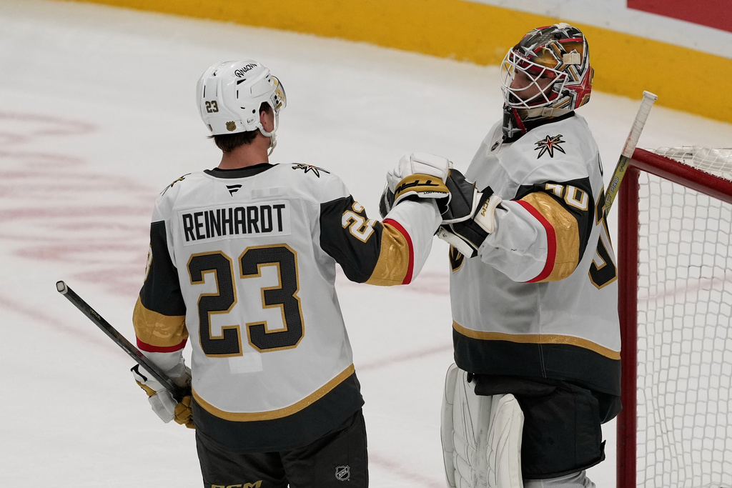 Vegas Golden Knights left wing Cole Reinhardt (23) celebrates with goaltender Carl Lindbom (30) after an NHL hockey game against the San Jose Sharks in San Jose, Calif., Sunday, Jan. 11, 2026. (AP Photo/Jeff Chiu)