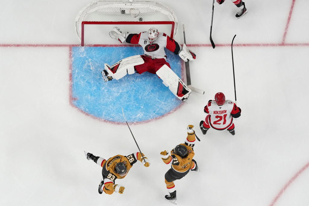 Vegas Golden Knights center William Karlsson (71) and Vegas Golden Knights right wing Mitch Marner (93) celebrate after Vegas Golden Knights defenseman Shea Theodore scored against Carolina Hurricanes goaltender Brandon Bussi (32) during the second overtime in Game 3 of the NHL hockey Stanley Cup Final series, Saturday, June 6, 2026, in Las Vegas. (AP Photo/John Locher)