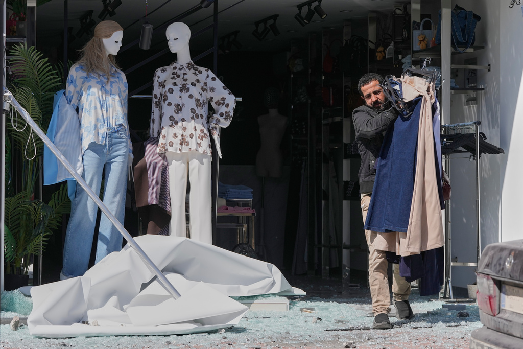 A man removes clothes from his damaged shop at a commercial street that was hit by an Israeli airstrike in Nabatiyeh town, south Lebanon, Thursday, March 5, 2026. (AP Photo/Mohammed Zaatari)