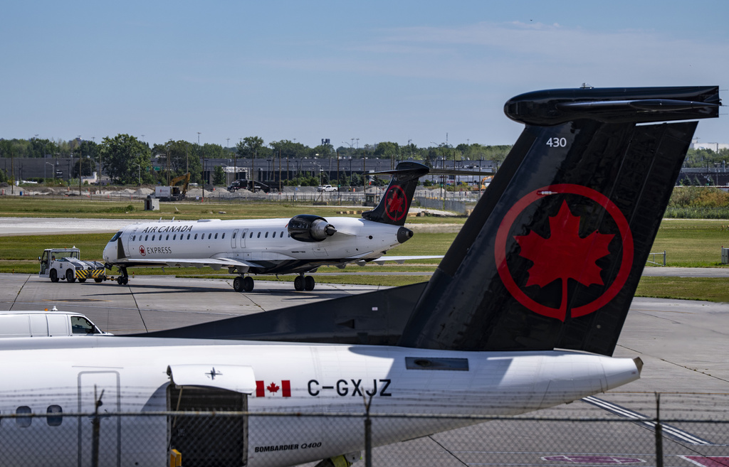An Air Canada plane gets a pushback from its gate at Montreal-Pierre Elliott Trudeau International Airport in Dorval, Que., on Tuesday, Aug. 19, 2025. (Christinne Muschi/The Canadian Press via AP)