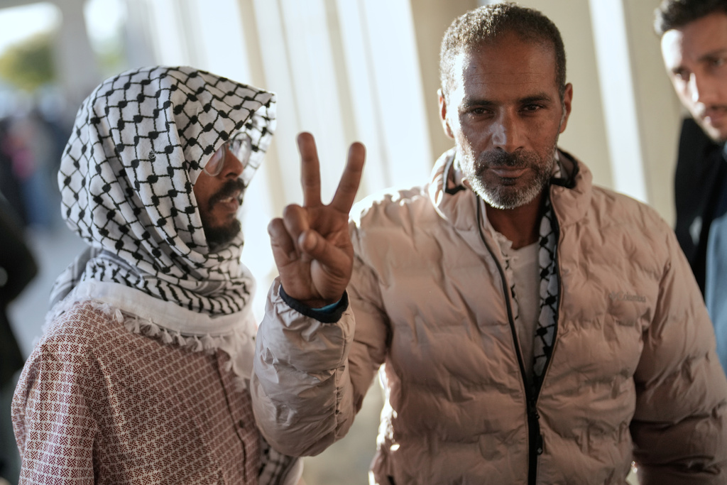 Activists from the Global Sumud Flotilla give the peace sign after arriving at Istanbul Airport in Istanbul, Turkey, Saturday, Oct. 4, 2025. (AP Photo/Khalil Hamra)