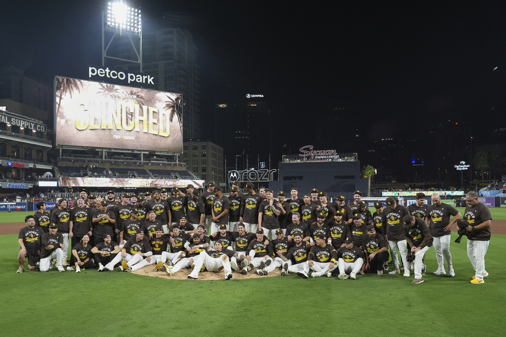 Members of the San Diego Padres pose for a picture after defeating the Milwaukee Brewers 5-4 in a baseball game to clinch a spot in the postseason Monday, Sept. 22, 2025, in San Diego. (AP Photo/Gregory Bull)