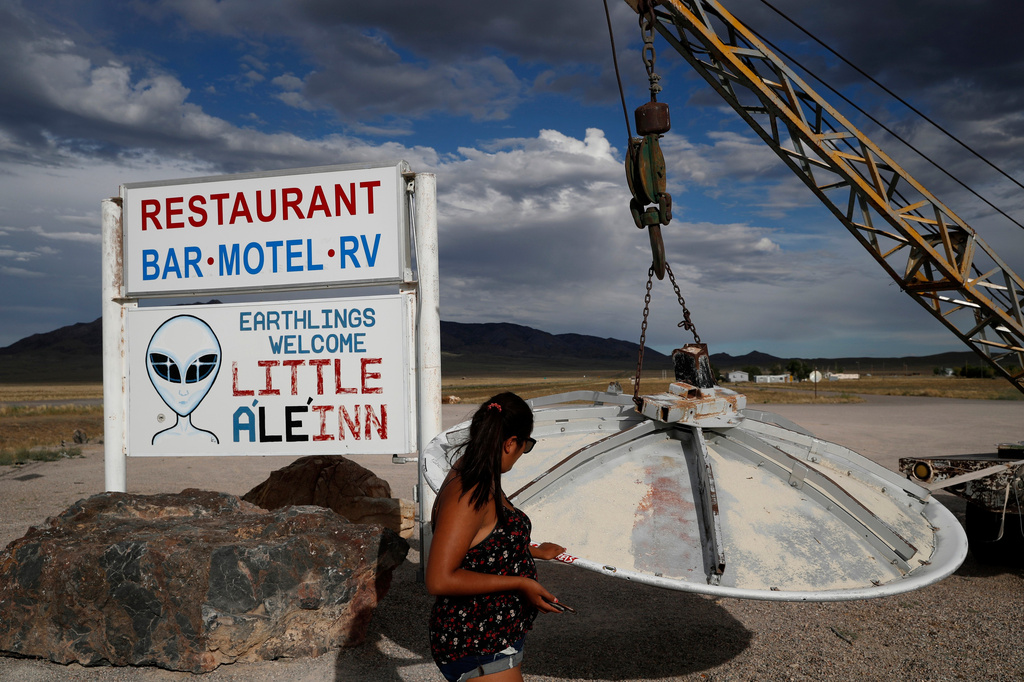 FILE - A woman looks at a UFO display outside of the Little A'Le'Inn, in Rachel, Nev., the closest town to Area 51, July 22, 2019. (AP Photo/John Locher, File)