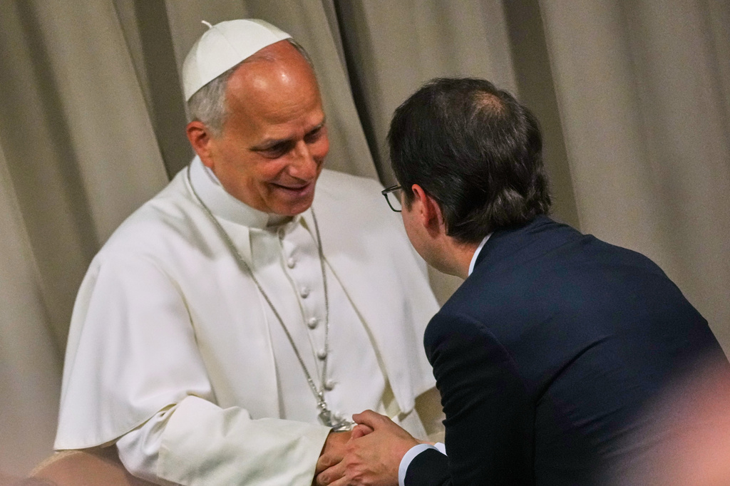 Pope Leo XIV, left, greets Anthropic co-founder Christopher Olah during the presentation of the Pope's first encyclical, "Magnifica humanitas: On Safeguarding the Human Person in the Time of Artificial Intelligence," at the Vatican, Monday, May 25, 2026. (AP Photo/Alessandra Tarantino)