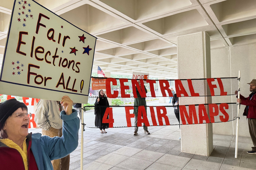 Protestors opposed to mid-decade redistricting wave signs outside of Florida’s Capitol building in Tallahassee, Fla. on Dec. 4, 2025. (AP Photo/Kate Payne)