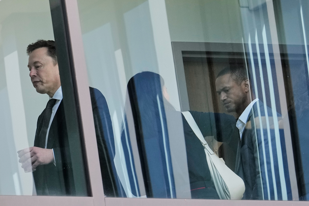 Elon Musk, left, walks through a hallway inside the U.S. District Court in Oakland, Calif., Wednesday, April 29, 2026. (AP Photo/Godofredo A. Vásquez)