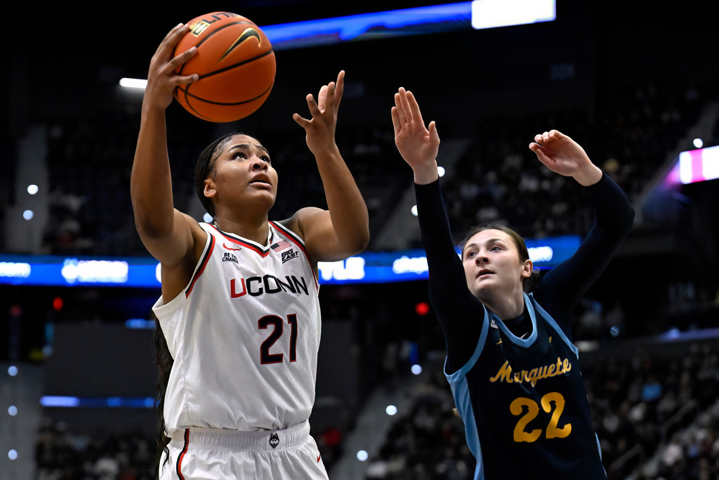 UConn forward Sarah Strong (21) goes up for a basket as Marquette guard Halle Vice (22) defends in the first half of an NCAA college basketball game, Wednesday, Dec. 17, 2025, in Hartford, Conn. (AP Photo/Jessica Hill)