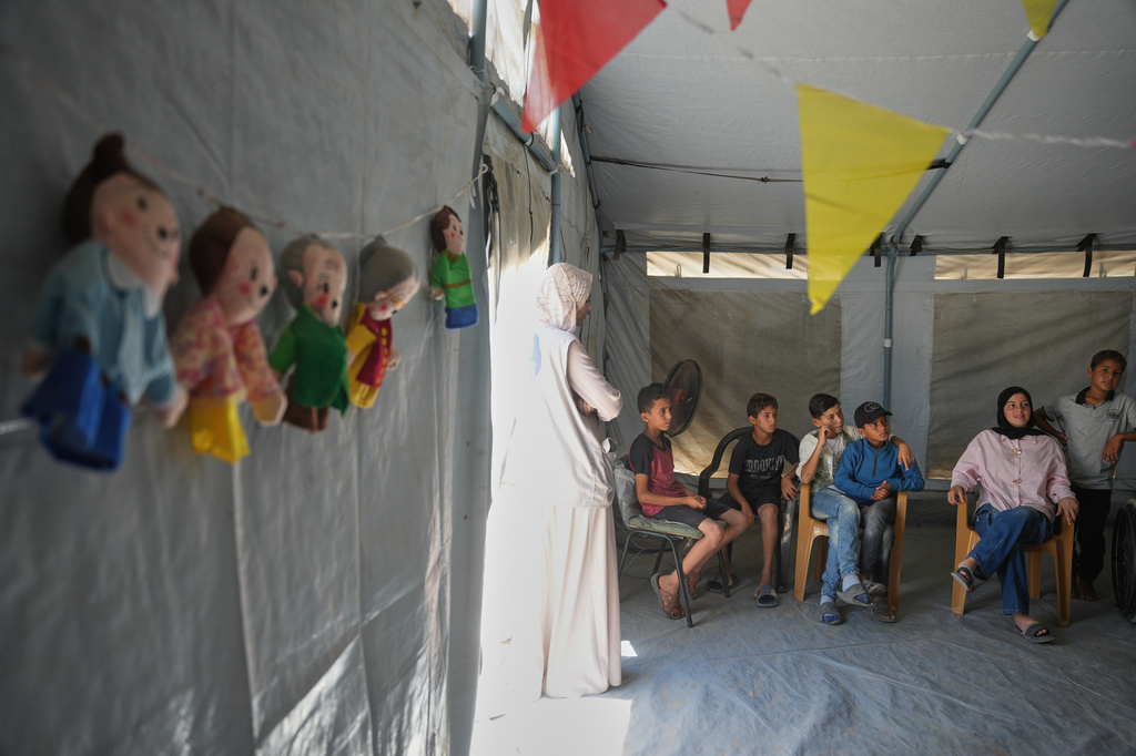 Palestinian children wait to receive a virtual reality psychosocial support session from a medical technology team in Zawaida, central Gaza Strip, Wednesday, June 17, 2026. (AP Photo/Abdel Kareem Hana)