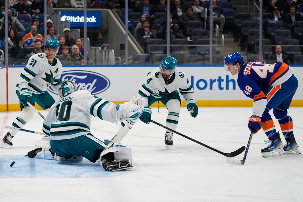 New York Islanders' Matthew Schaefer (48) shoots the puck past San Jose Sharks goaltender Yaroslav Askarov (30) for a goal during the second period of an NHL hockey game Tuesday, Oct. 21, 2025, at UBS Arena in Elmont, N.Y. (AP Photo/Frank Franklin II)