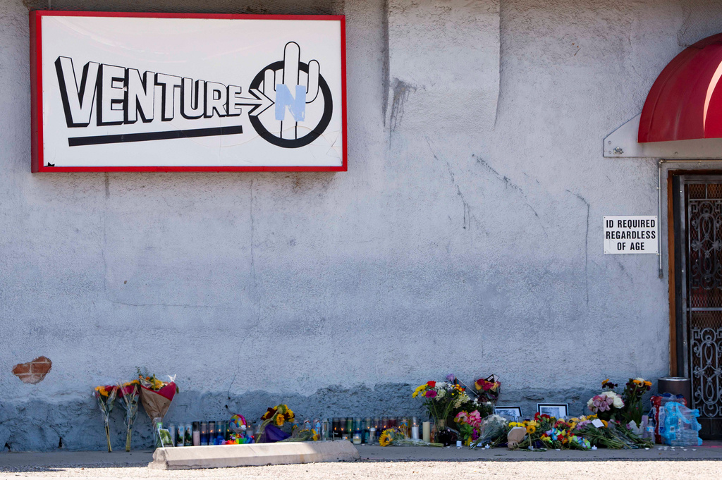 A growing memorial sits outside the Venture-N Bar in Tucson, Ariz., Tuesday, Sept. 1, 2026, for Vincent Siquieros and Cameron Capara, who were fatally shot in the parking lot of the gay bar shortly after midnight Monday. (AP Photo/Rebecca Noble)