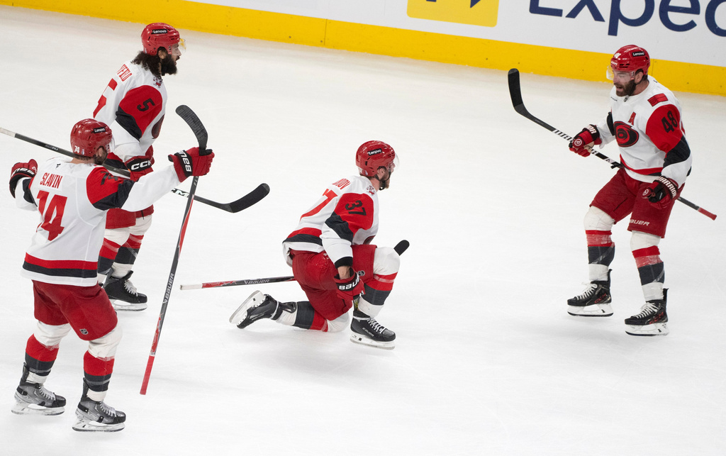 Carolina Hurricanes' Andrei Svechnikov (37) celebrates with teammates Jaccob Slavin (74), Jalen Chatfield (5) and Jordan Martinook (48) after his goal during overtime of Game 3 of the Eastern Conference finals NHL hockey Stanley Cup playoff series against the Montreal Canadiens in Montreal, Monday, May 25, 2026. (Christinne Muschi/The Canadian Press via AP) CORRECTION: Corrected the goal scorer to Andrei Svechnikov