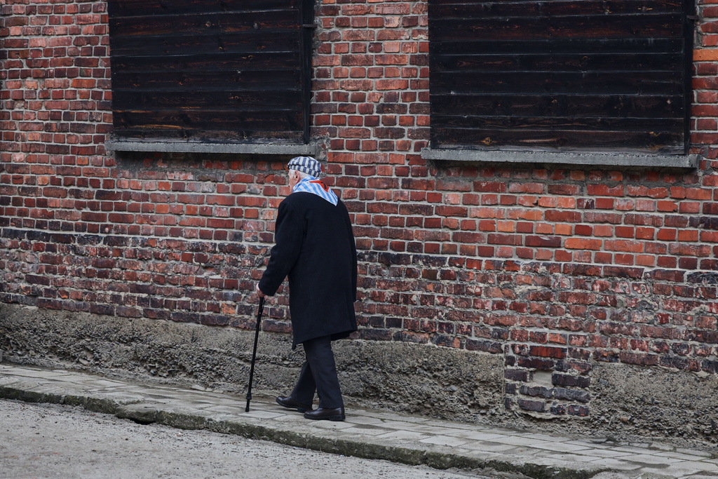 Holocaust survivor Stanislaw Zalewski walks along a wall in the Auschwitz Nazi death camp museum during a ceremony marking the 81th anniversary of the camp's liberation in Oswiecim, Poland, Tuesday, Jan. 27, 2026. (AP Photo/Beata Zawrzel)