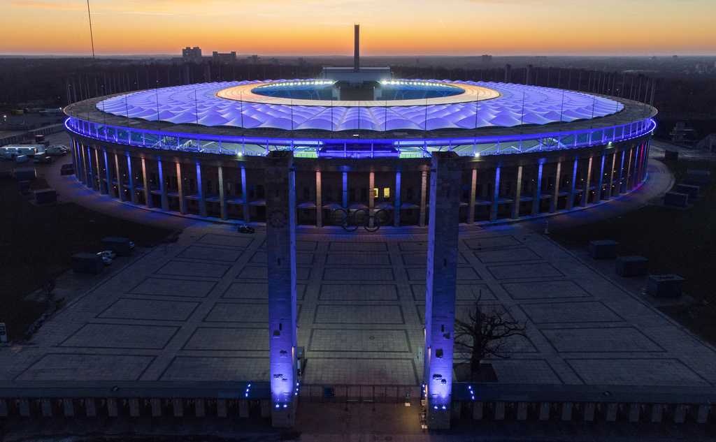 FILE - The Olympic Stadium is illuminated as the sun sets after the German Bundesliga soccer match between Hertha BSC Berlin and RB Leipzig in Berlin, Germany, Feb. 21, 2021. (AP Photo/Michael Sohn, File)