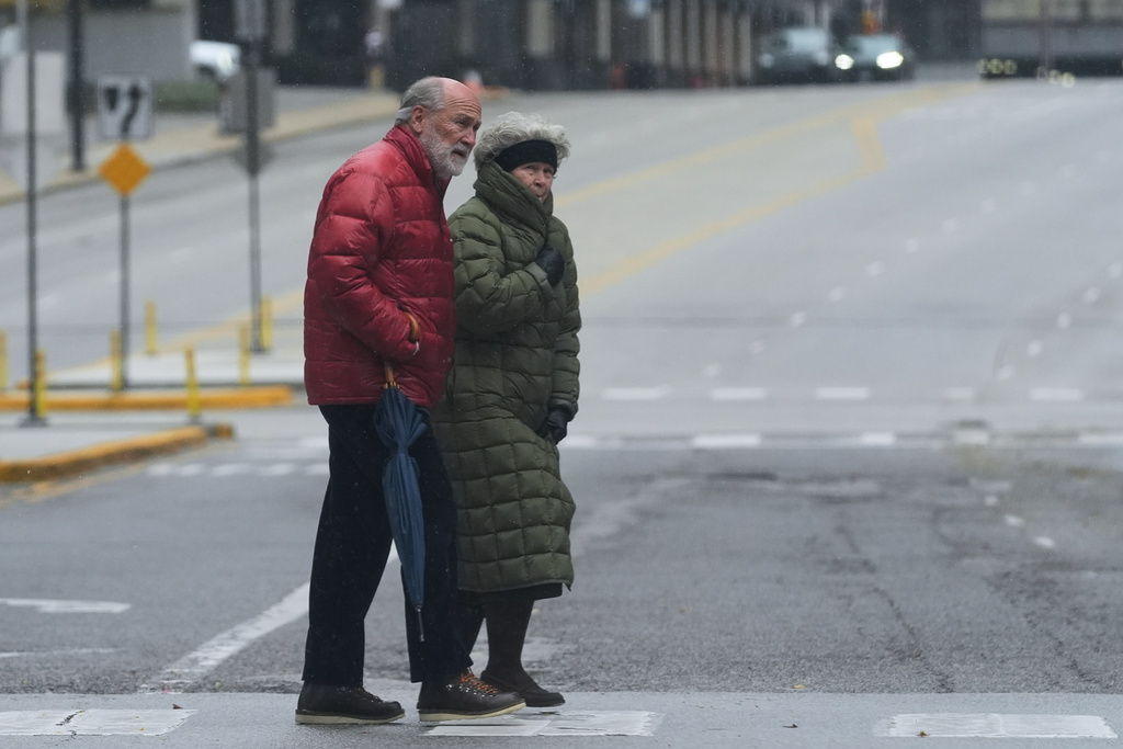 Pedestrians cross a street during a cold day in Chicago, Sunday, Nov. 9, 2025. (AP Photo/Nam Y. Huh)