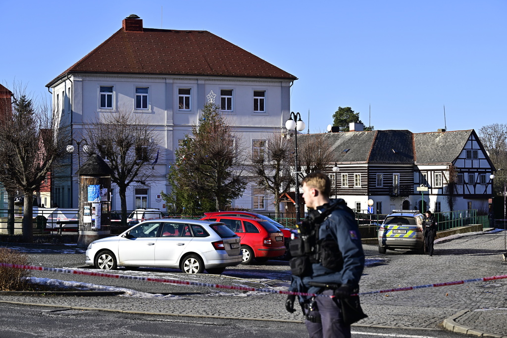 A police officer stands in front of the town hall in Chribska, Czech Republic, Monday, Jan. 19, 2026, after a shooting that has left one dead and four others wounded. (Ondrej Hajek/CTK via AP)