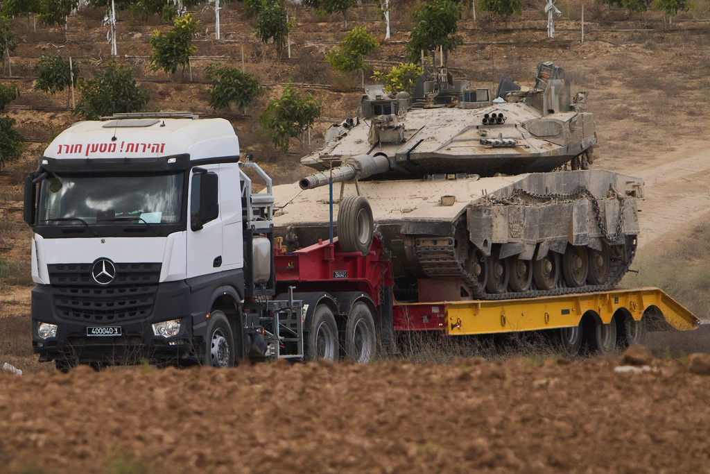 A truck carries a military tank from inside the Gaza Strip in southern Israel, Thursday, Oct. 9, 2025, following the announcement that Israel and Hamas have agreed to the first phase of a peace plan to pause the fighting. (AP Photo/Ariel Schalit)