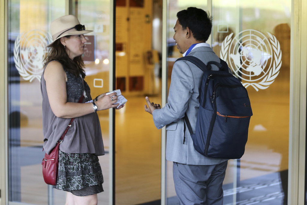 Gallifrey Foundation spokesperson Laurianne Trimoulla hands out boxes of soap to convey their message as she awaits delegates to the plastic pollution treaty talks at the United Nations office in Geneva, Switzerland, Wednesday, Aug. 13, 2025. (AP Photo/ Jennifer McDermott)