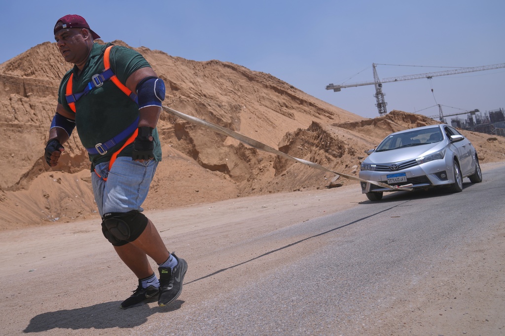 Egyptian wrestler Ashraf Mahrous, also known as Kabonga, pulls a car during a training session in Cairo, Egypt, Thursday, July 24, 2025. (AP Photo/Amr Nabil)