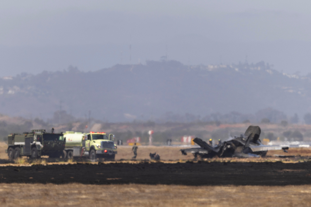 Crews work to douse a F-35 fighter jet that crashed near the run way at Marine Corps Air Station Miramar on Friday, July 31, 2026, in San Diego. (Luke Johnson/The San Diego Union-Tribune via AP)