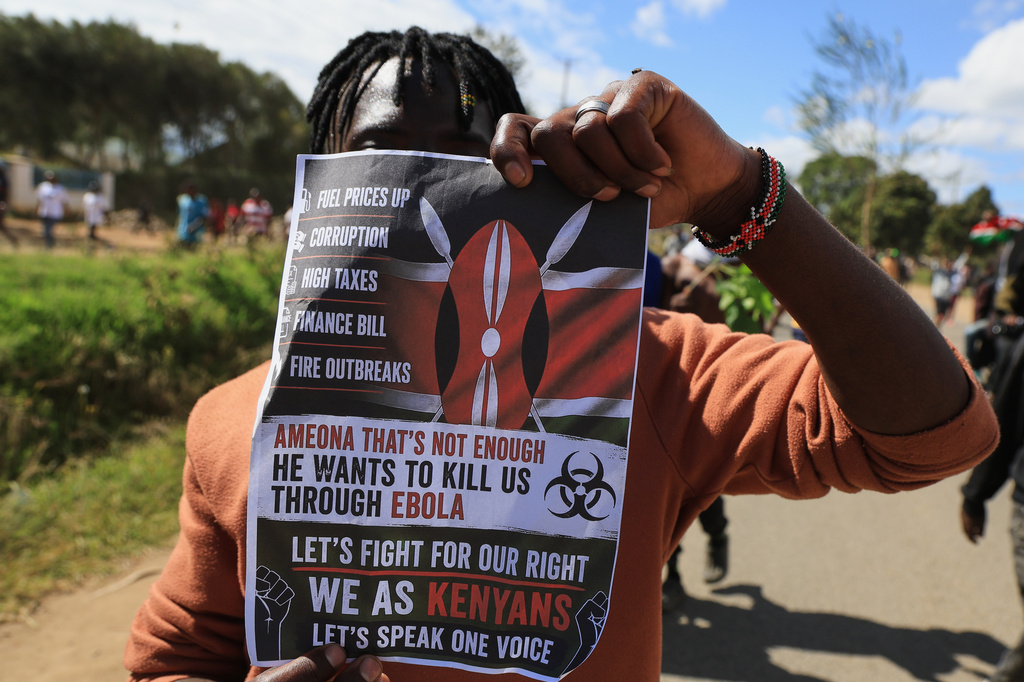 A protester holds up a placard during a demonstration against a proposed Ebola quarantine center to be established by the United States at Laikipia Air Base in Nanyuki, Kenya, Monday, June 1, 2026. (AP Photo/Andrew Kasuku)