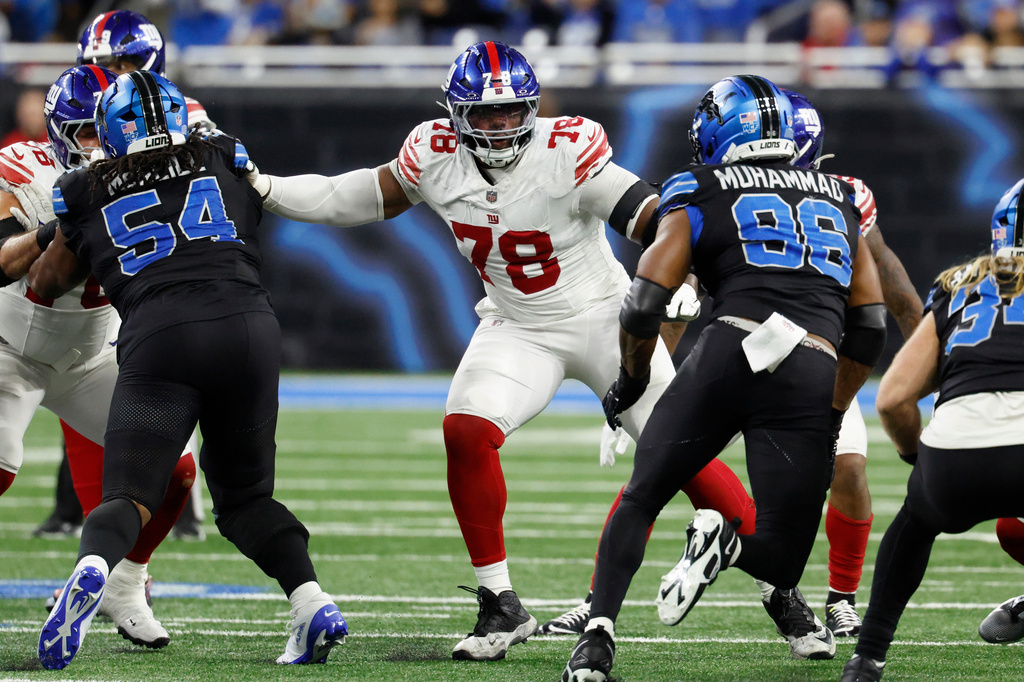 FILE - New York Giants offensive tackle Andrew Thomas (78) blocks Detroit Lions linebacker Al-Quadin Muhammad (96) during an NFL football game in Detroit, Nov. 23, 2025. (AP Photo/Rick Osentoski, file)