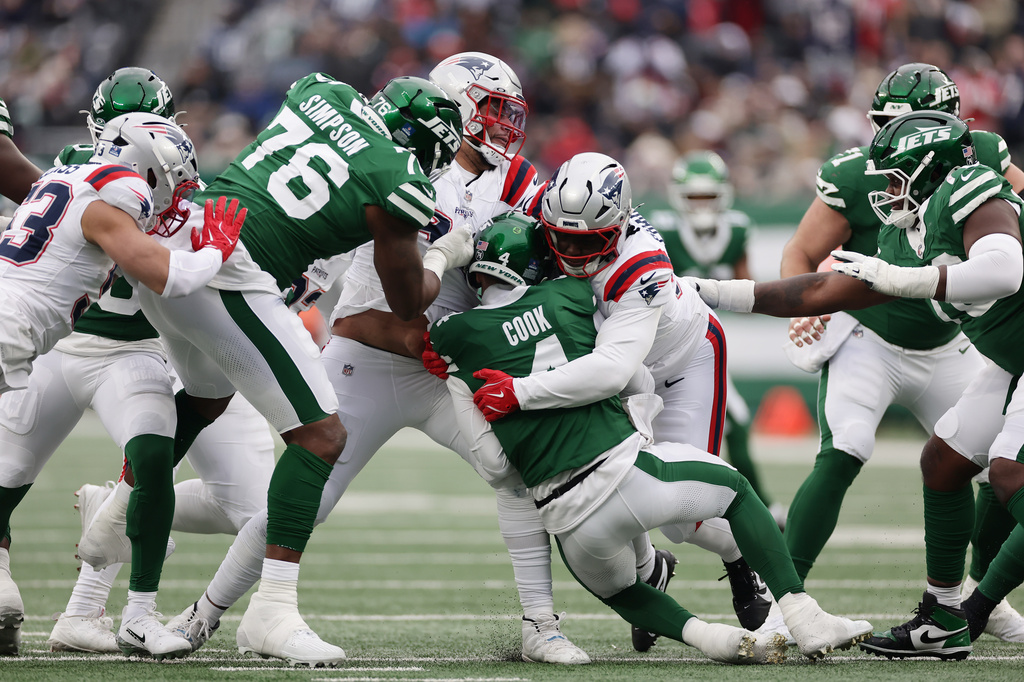 New England Patriots defensive tackle Jeremiah Pharms Jr., center right, sacks New York Jets quarterback Brady Cook, center left, during the second half of an NFL football game, Sunday, Dec. 28, 2025, in East Rutherford, N.J. (AP Photo/Adam Hunger)