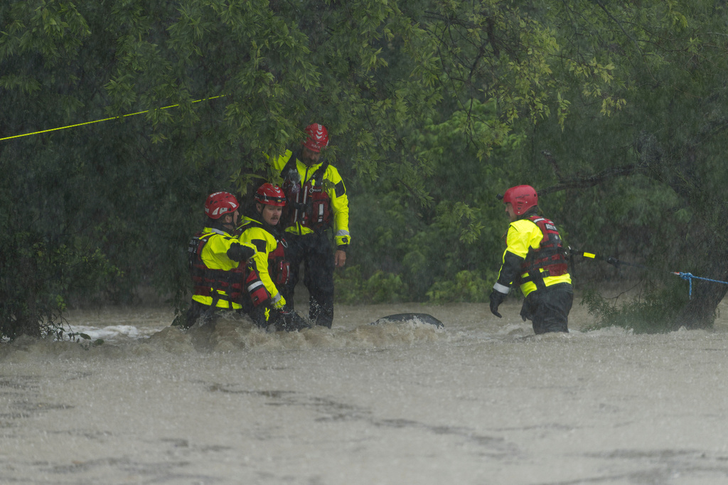 Members of the Boerne Fire Dept. maneuver through flood waters during a water rescue on Wednesday, July 15, 2026, in Boerne, Texas. (AP Photo/Darren Abate)