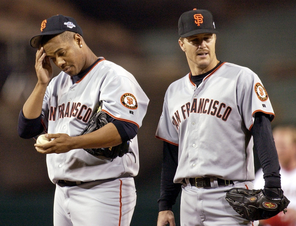 FILE - San Francisco Giants Livan Hernandez, left, and Jeff Kent react after the Anaheim Angels Garret Anderson hit a three run RBI double in the third inning during game 7 of the World Series in Anaheim, Calif., on Oct. 27, 2002. (AP Photo/Mark J. Terrill, File)